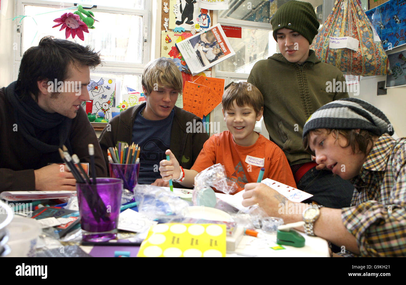 Pop band McFly (left to right) Harry Judd, Dougie Poynter, Tom Fletcher and Danny Jones help Fergus Hunt, age 11, from Chelmesford Essex, design a Christmas card at Great Ormond Street Children's Hospital, central London. Stock Photo