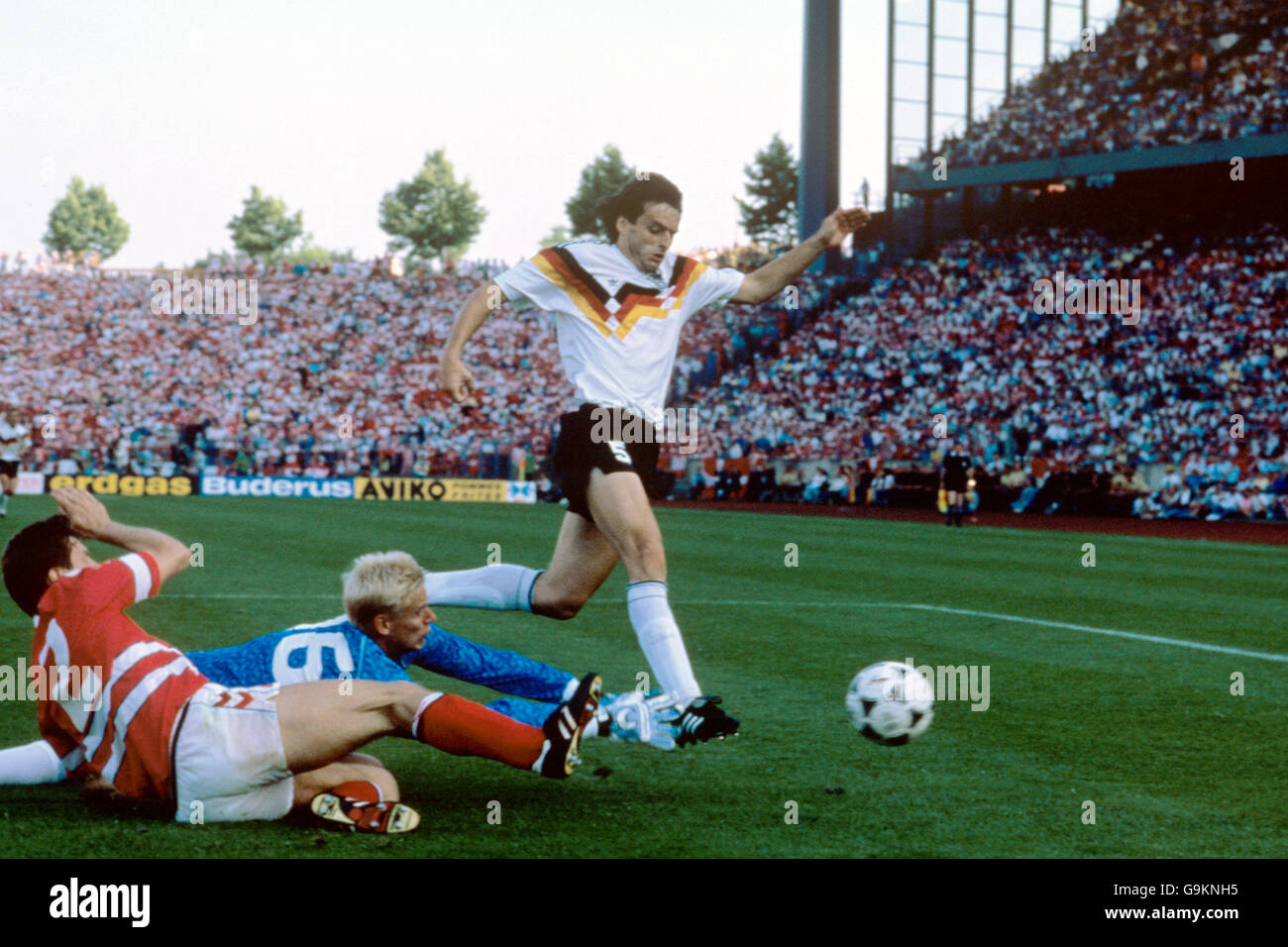 Soccer - European Championships - Group One - West Germany v Denmark - Parkstadion. West Germany's Matthias Herget (r) reaches the ball ahead of Denmark's John Sivebaek (l) and Peter Schmeichel (c) Stock Photo
