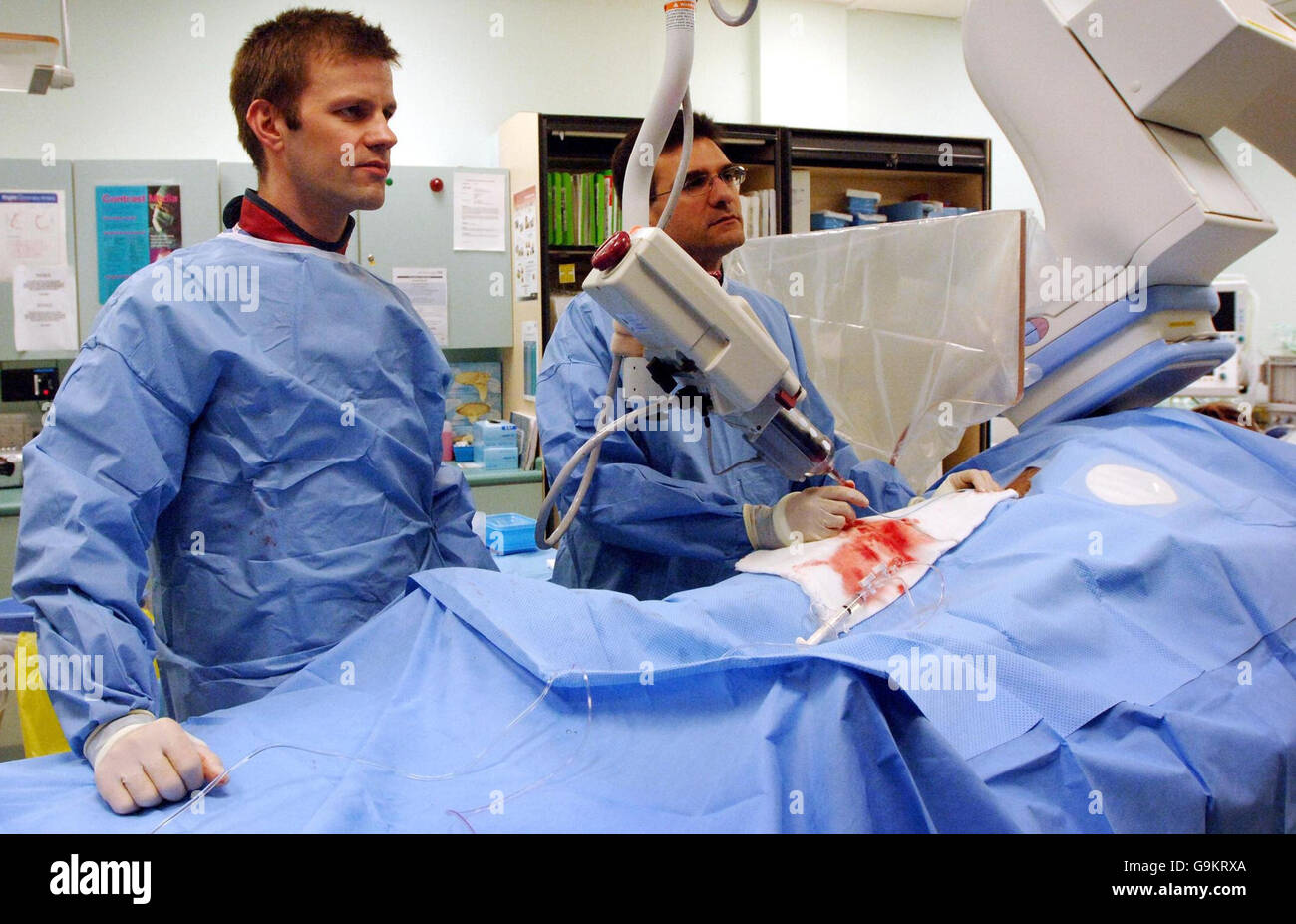 Consultant cardiologist Dr Anthony Mathur (right) and registrar Julian Strange perform an angiogram, an exploratory heart operation at London Chest Hospital, after the British Heart Fdoundation' s poster campaign was launched, which encourages the public to phone 999 first if they suspect they are having a heart attack. Stock Photo
