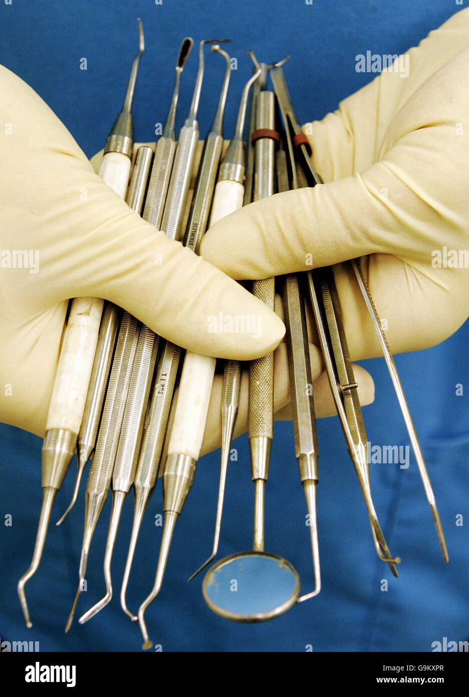 A dental nurse holds dental instruments hires stock photography and
