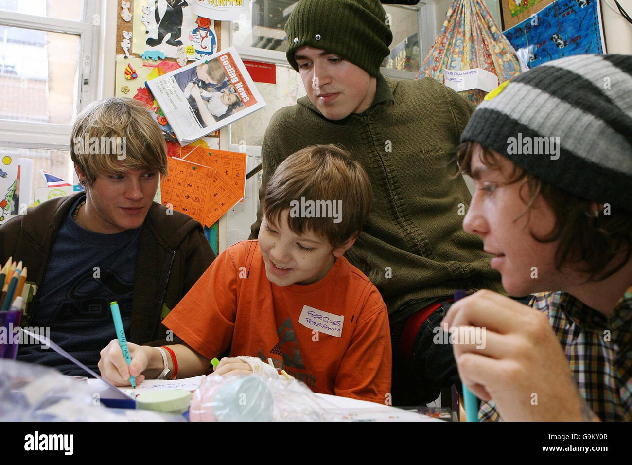 Members of McFly (left to right) Dougie Poynter, Tom Fletcher and Danny Jones help Fergus Hunt, age 11 from Chelmsford in Essex, design a Christmas card at Great Ormond Street Children's Hospital in central London. Stock Photo