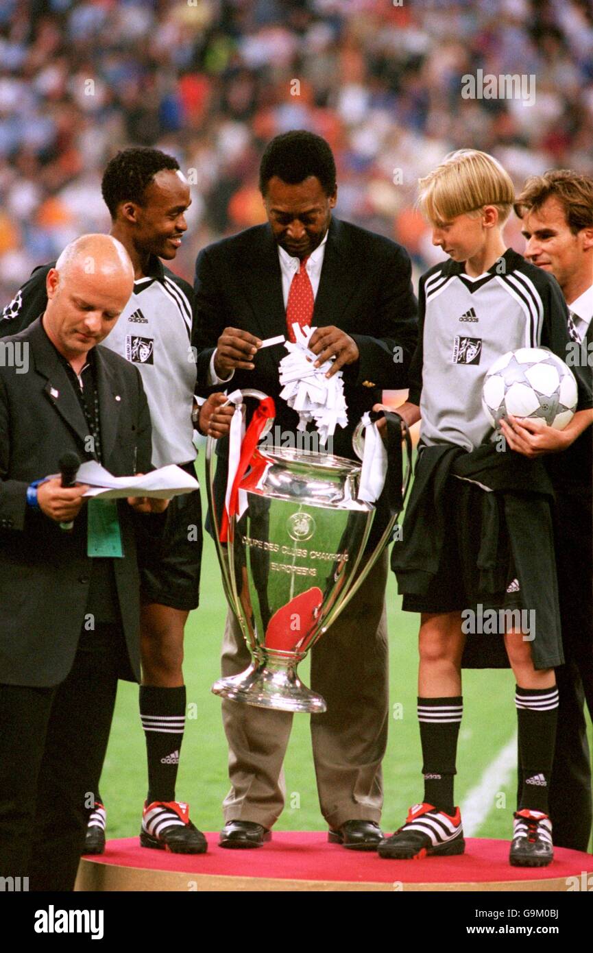 Pele (c) performs a prize draw using the European Cup, held by Sonny (the  star of Adidas' 'I Kiss Football' advertising campaign) and a friend, as a  handy container from which to