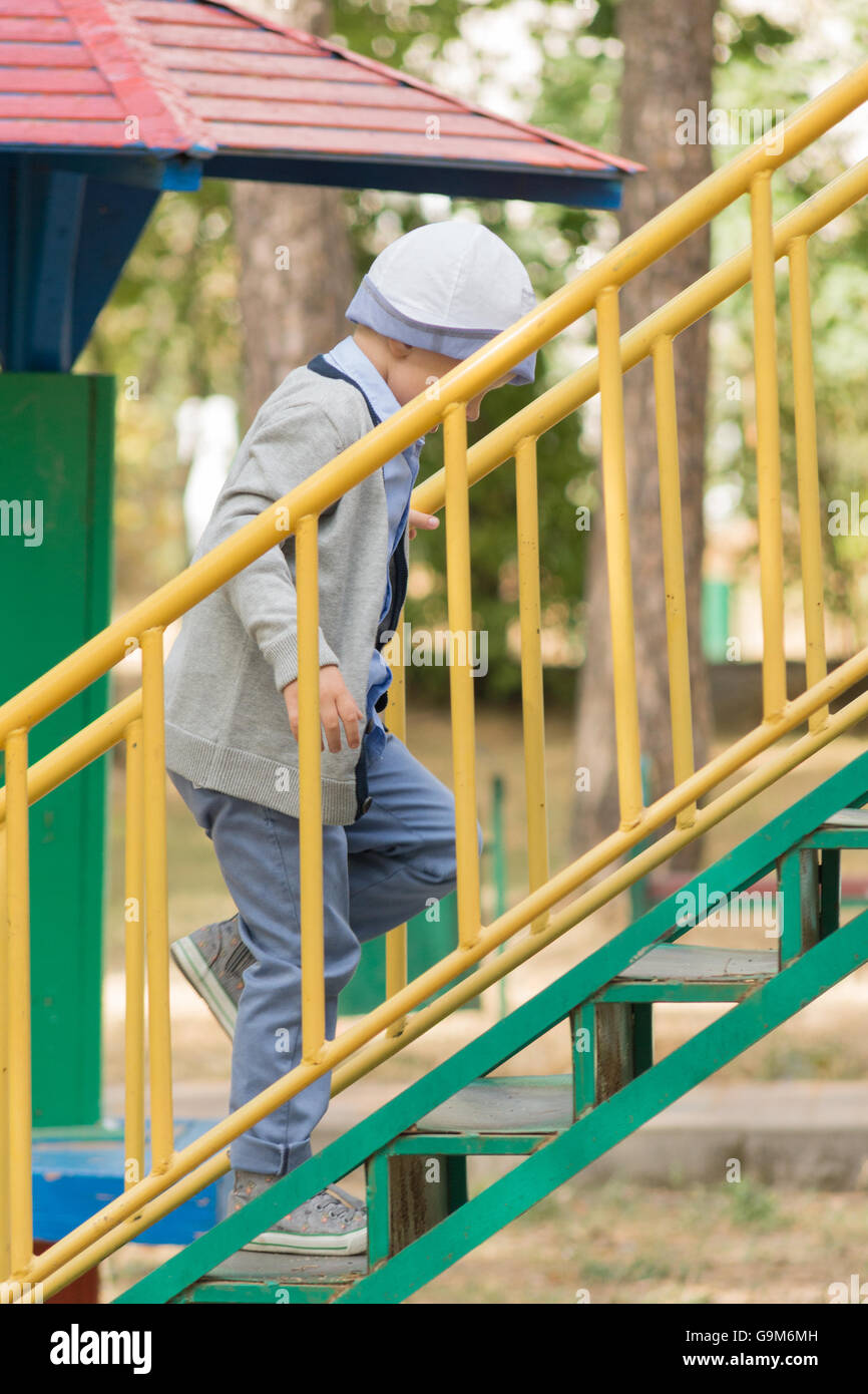 the boy in the dress has a good time on a game ladder Stock Photo