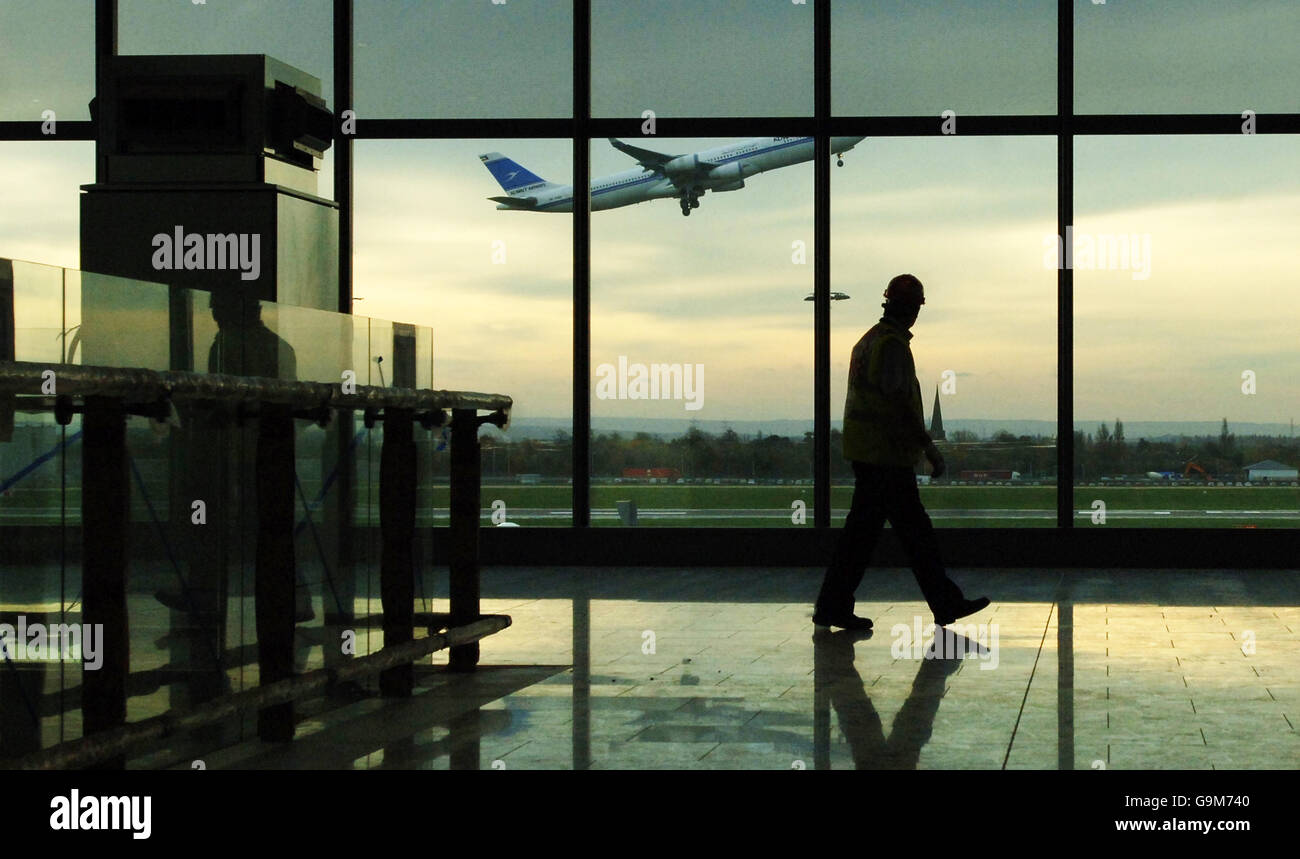 A worker walks past the panoramic window of one of the two satellites