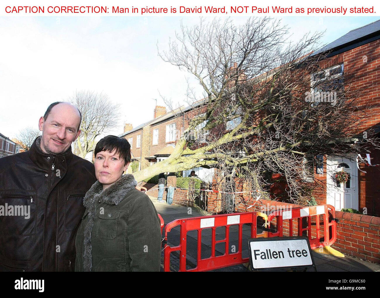 David and Dianne Ward stand outside their home, which was hit by a falling tree during heavy storms. Stock Photo