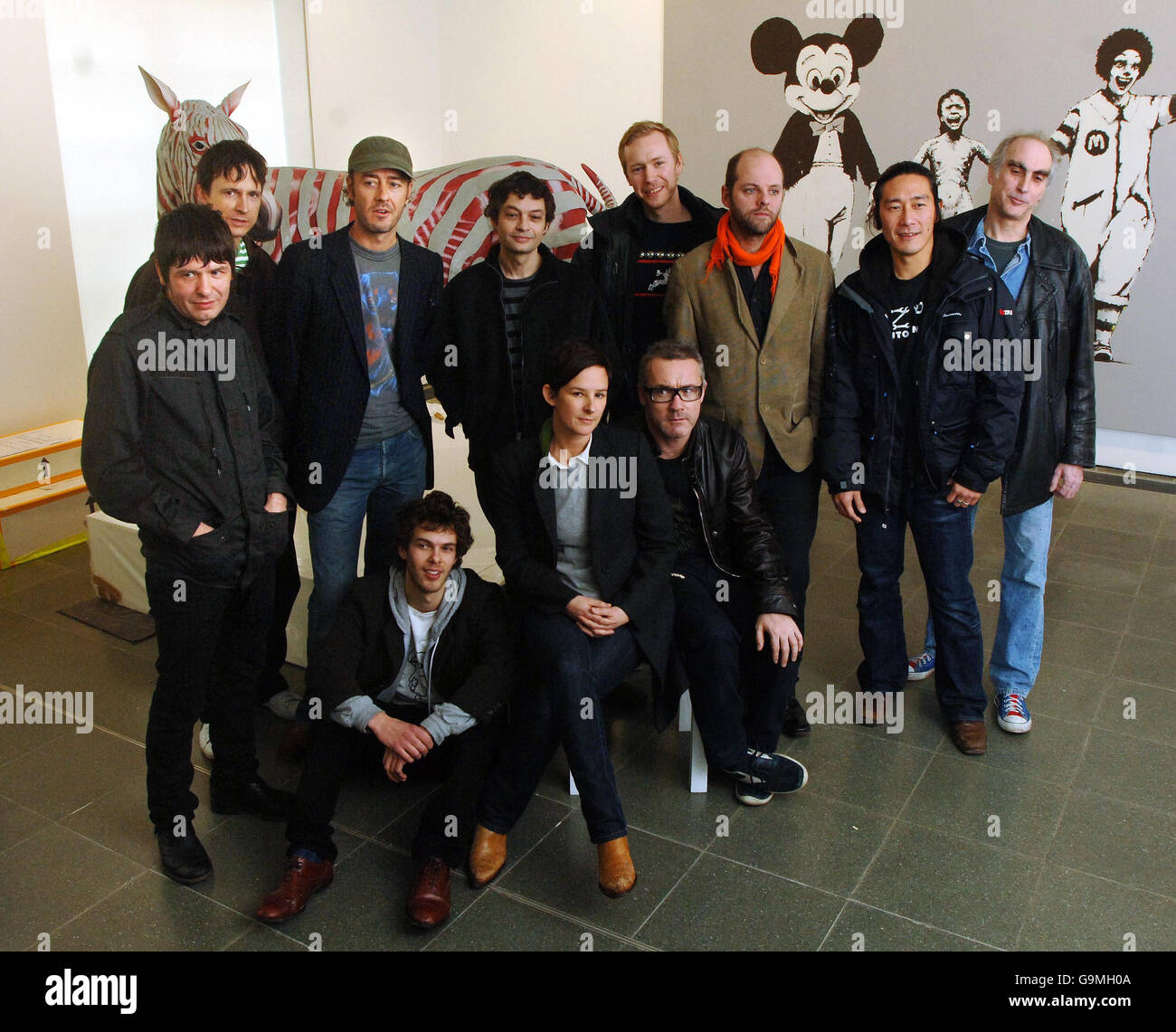 Artists (left to right); Jim Lambie, Nick Lumb, John Isaacs, Tim Lewis,Tom Ormond, Gavin Turk, Michael Joo and Stephen Gregory and (seated, from left to right); Lawrence Owen, Rachel Howard and Damien Hirst at London's Serpentine Gallery, where works from Hirst's 'murderme', his personal contemporary art collection, are exhibited from tomorrow. Stock Photo