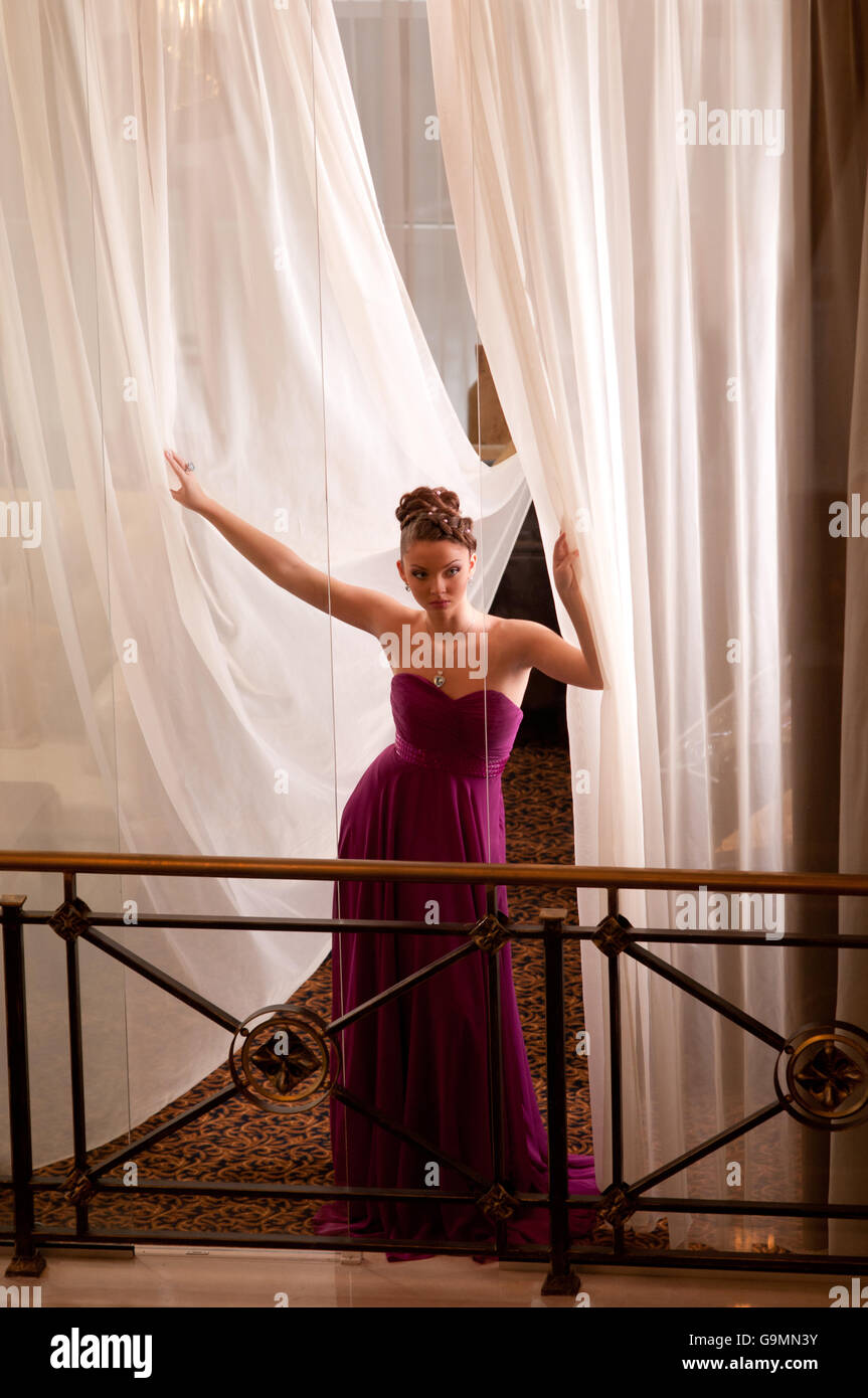 an attractive young woman in long dress standing on the balcony Stock ...