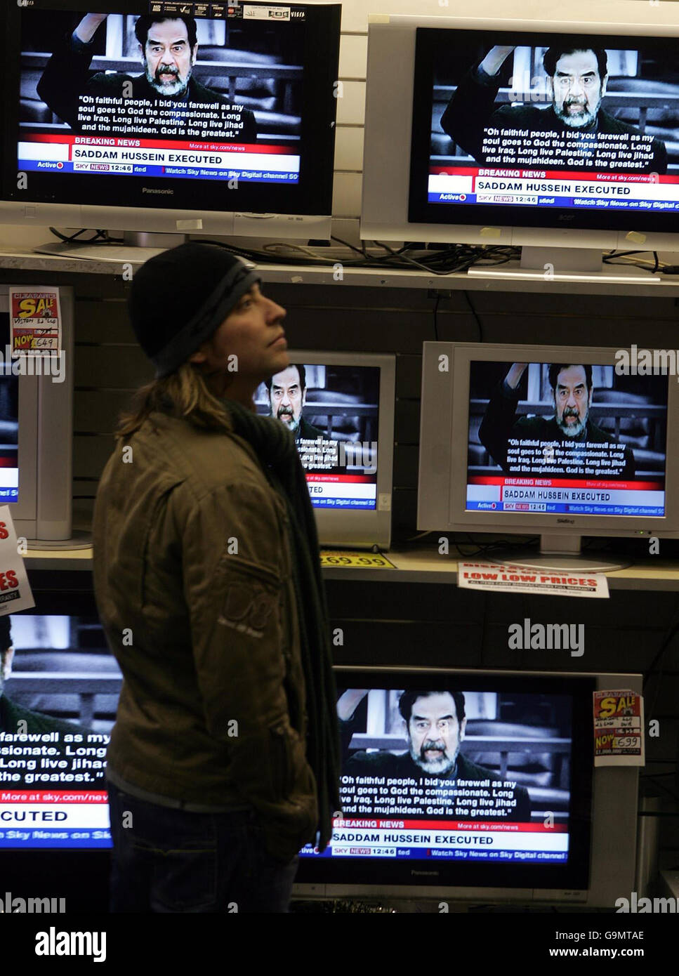 A man watches a television in an electrical store in central London, as broadcasters report on the reaction to the execution of Saddam Hussein that occurred in Iraq earlier today. Stock Photo