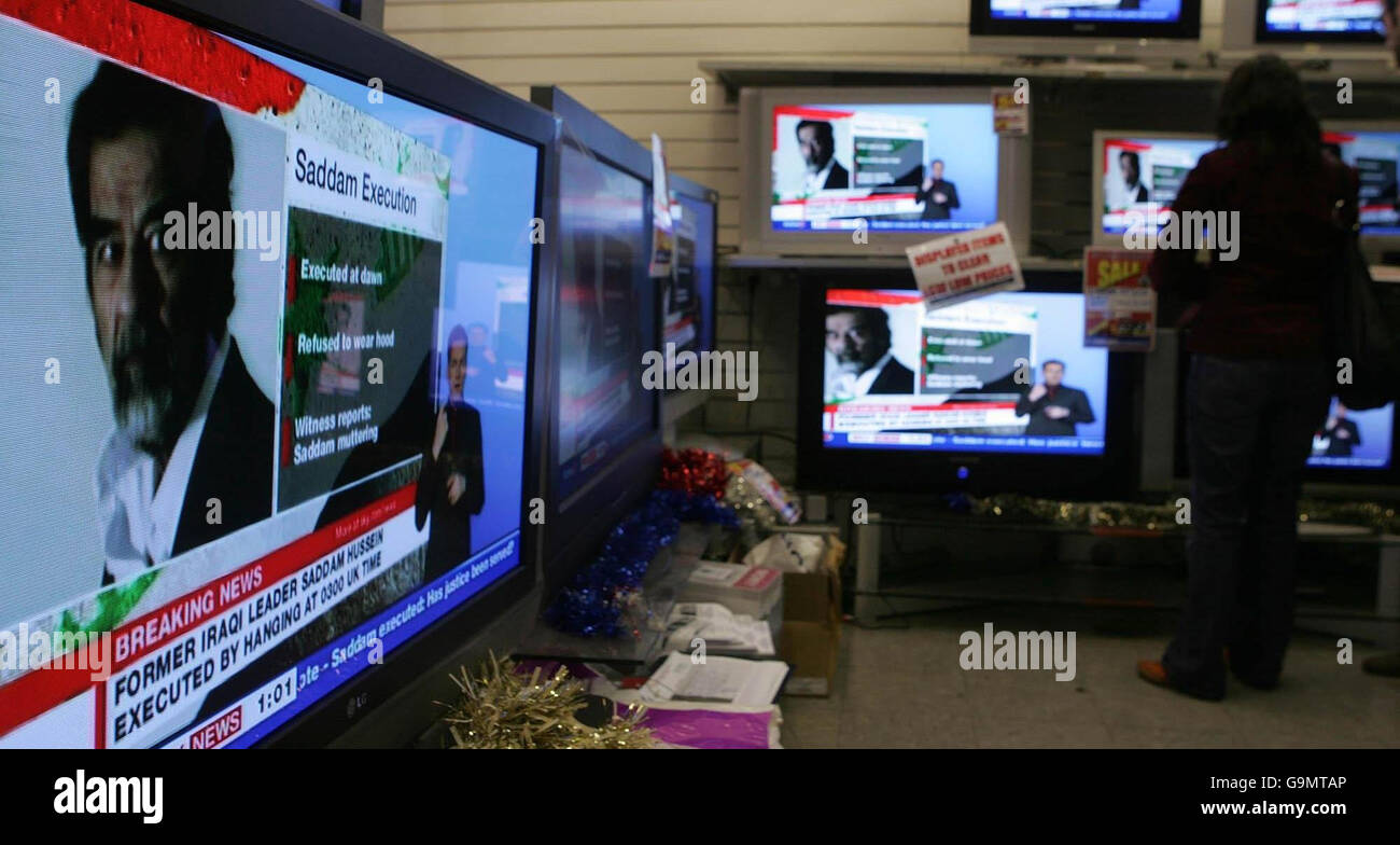 A man and woman watch a television in an electrical store in central London, as broadcasters report on the reaction to the execution of Saddam Hussein that occurred in Iraq earlier today. Stock Photo