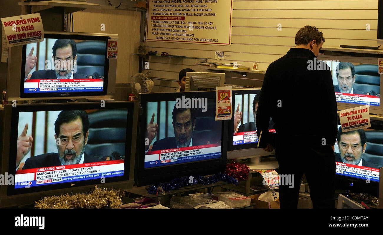 A man watches a television in an electrical store in central London, as broadcasters report on the reaction to the execution of Saddam Hussein that occurred in Iraq earlier today. Stock Photo