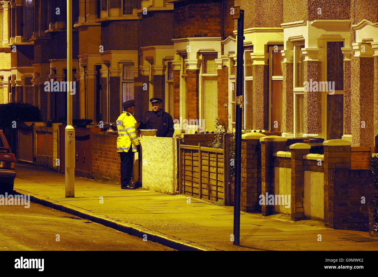 Police officers stands outside a house in Nelson Street, in East Ham