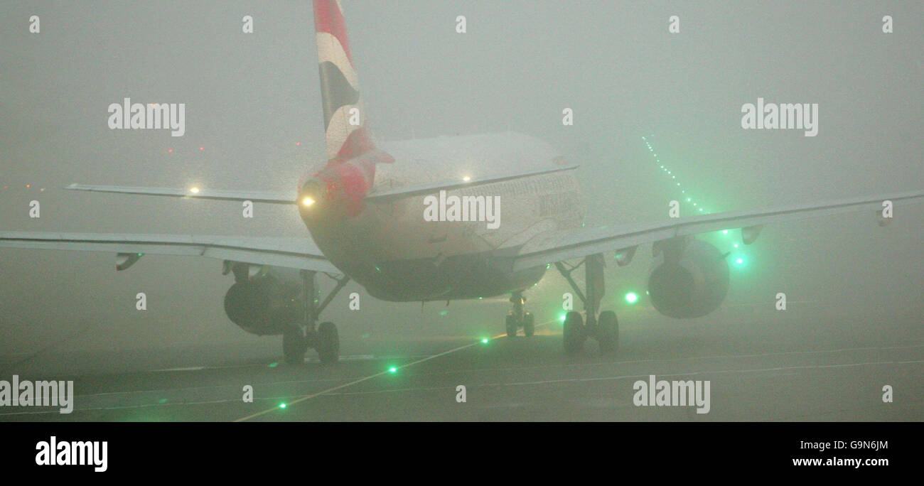 A BA Boeing 737 flight taxi's out of Heathrows Terminal 1 into the freezing fog for take off. Stock Photo