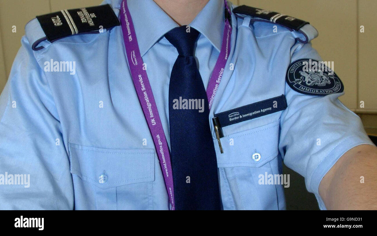 An Immigration officer wearing a new uniform checks a passport from a  passenger arriving at Terminal 1 at Heathrow Airport Stock Photo - Alamy