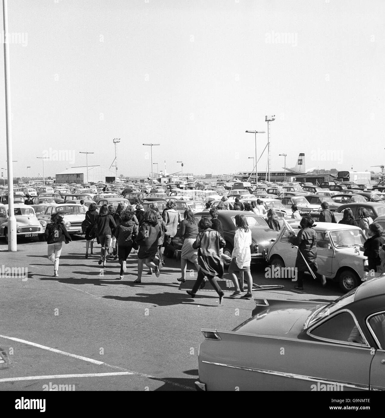 Fans break through the staff car park in an attempt to get near The Beatles as the group leaves London Airport for a Continental tour taking in France, Italy and Spain. Stock Photo