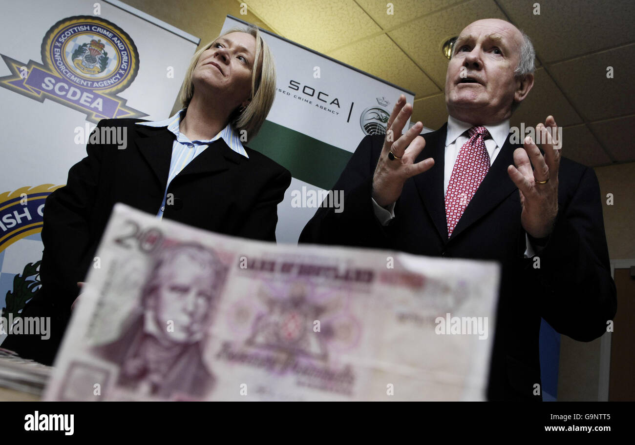 Home Secretary John Reid and Scottish Minister for Justice Cathy Jamieson with a seized counterfeit note at the Scottish Crime and Drugs Enforcement Agency in Paisley. Stock Photo