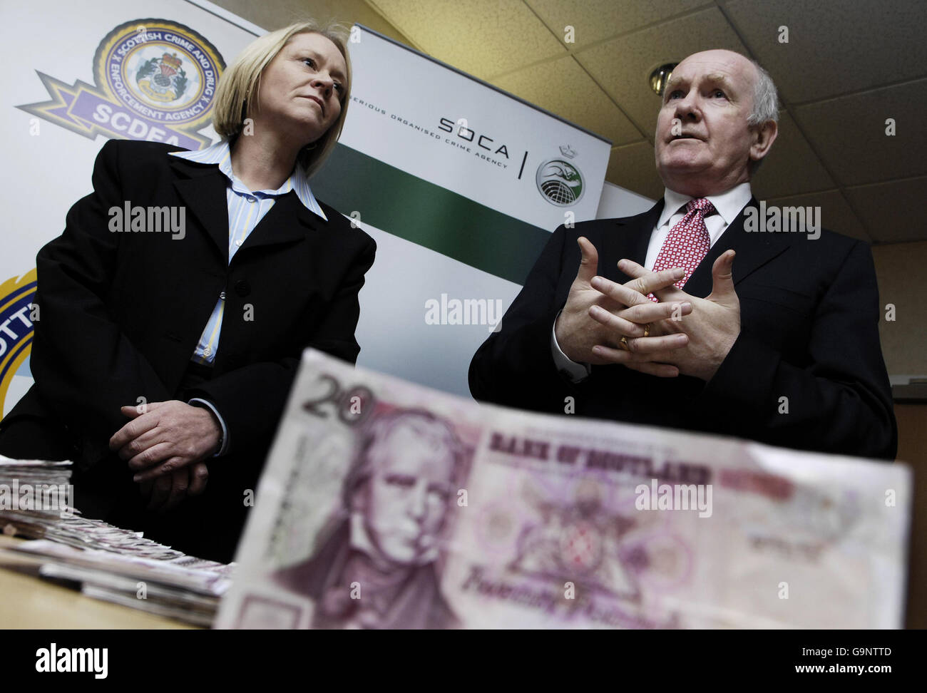 Home Secretary John Reid (right) and Scottish Minister for Justice Cathy Jamieson (left) with a seized counterfeit note at the Scottish Crime and Drugs Enforcement Agency in Paisley. Stock Photo