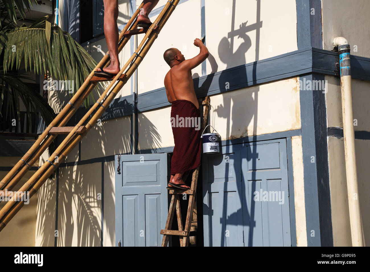 Buddhist monks paint a building at monastery in Pyin Oo Lwin, Myanmar. Stock Photo