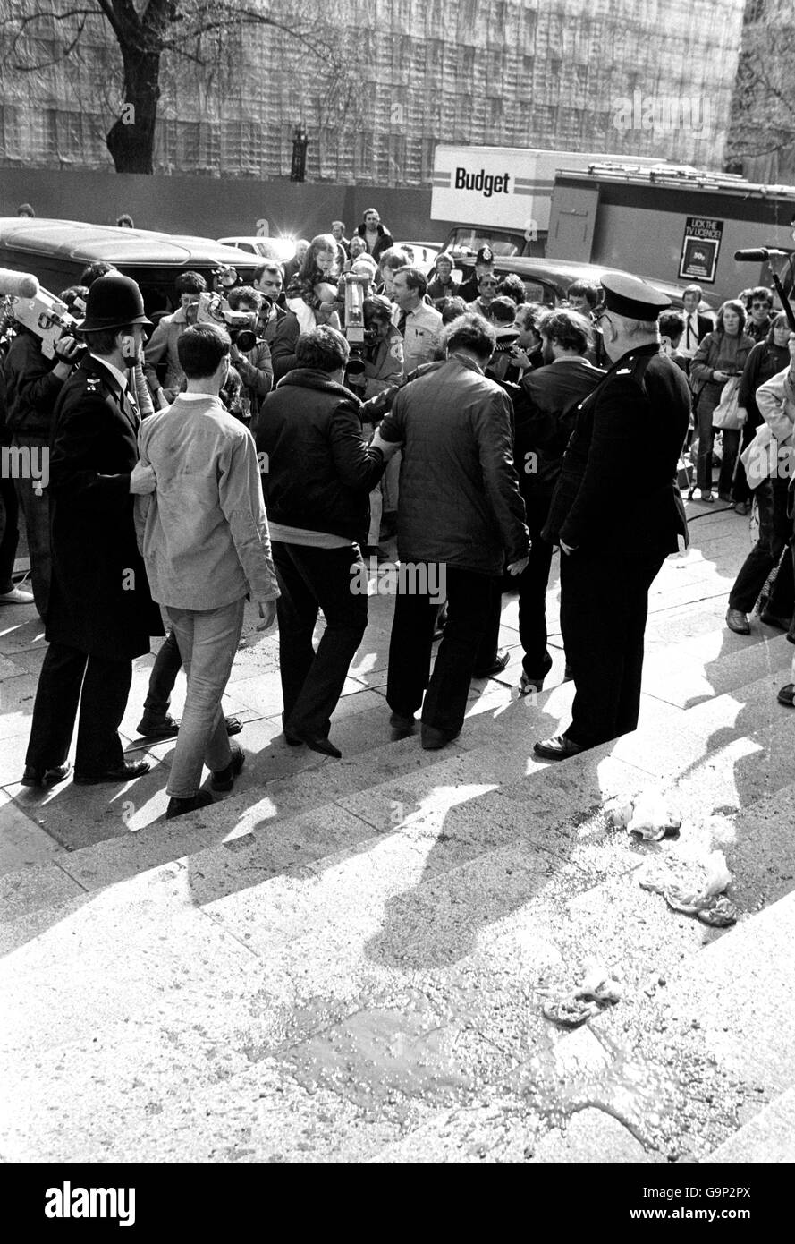 Police leading away demonstrators from outside the Ministry of Defence in London after they splattered home made 'blood' on the Ministry steps. Stock Photo