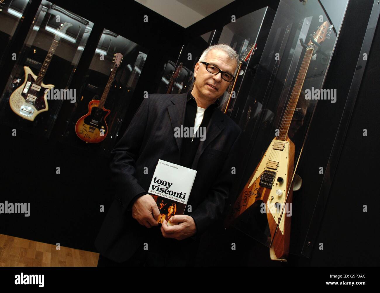 Legendary American music producer Tony Visconti poses next to a 1970 Hoyer Flying Arrow guitar, as played by Marc Bolan, during a signing session for his book 'Bowie, Bolan and the Brooklyn Boy', at Harrods in central London. Stock Photo