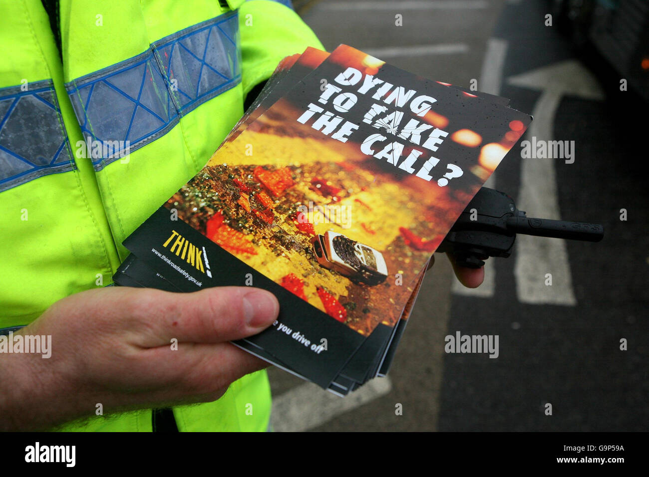 A police officer holds a police leaflet posing the question 'Dying to