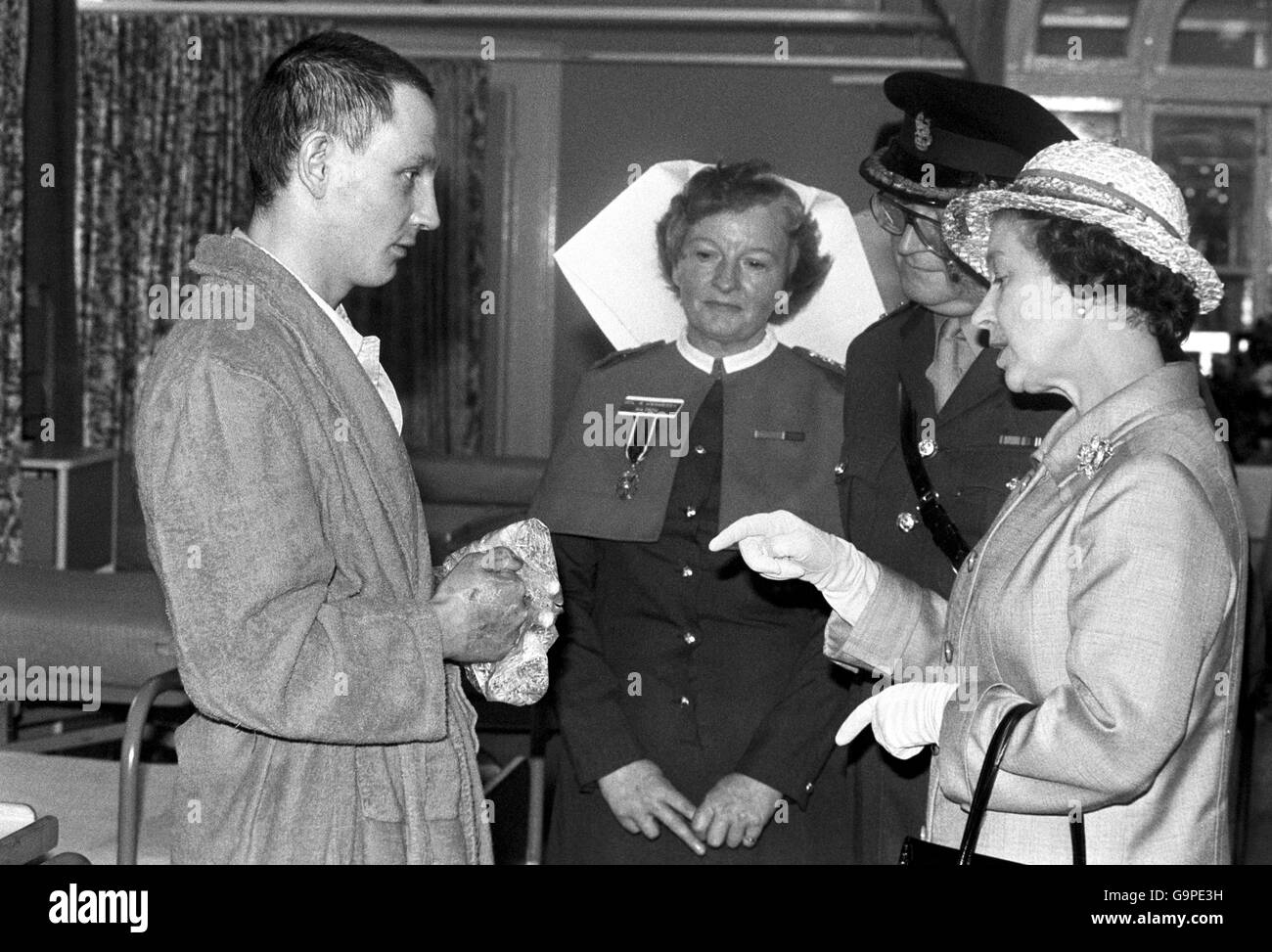 The Queen talking with Lance Sgt Graham Evans, of the Welsh Guards, when she visited was wounded from the Falklands at the Cambridge Military Hospital at Aldershot. He received burns to his hands and face when the RFA ship Sir Galahad was bombed by Argentinans at Bluff Cove. Stock Photo