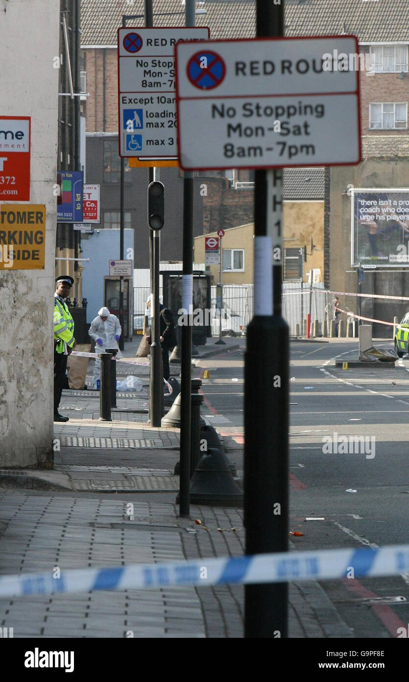 Scene of Crime Officers and forensics investigate the scene where a man was shot dead in the early hours of this morning on Homerton High Street in Hackney, east London. Stock Photo