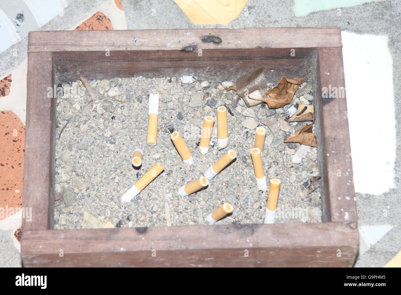 Cigarette butts in a big ashtray full of sand Stock Photo