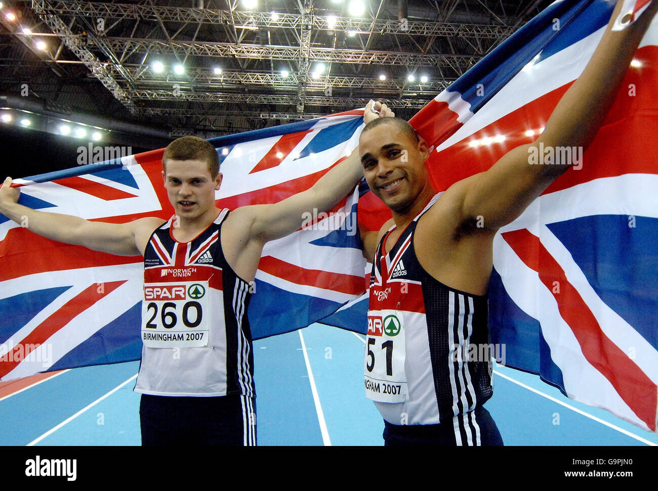 Great Britain's Jason Gardener (right) celebrates after taking first place in the 60m relay, as teammate Craig Pickering celebrates second place during the European Athletics Indoor Championships at the National Indoor Arena, Birmingham. Stock Photo