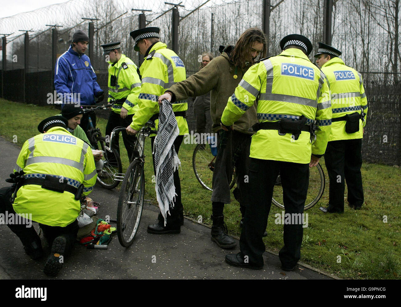 Trident protesters are searched by police outside the north gate of the Naval Base at Faslane, Scotland. Stock Photo