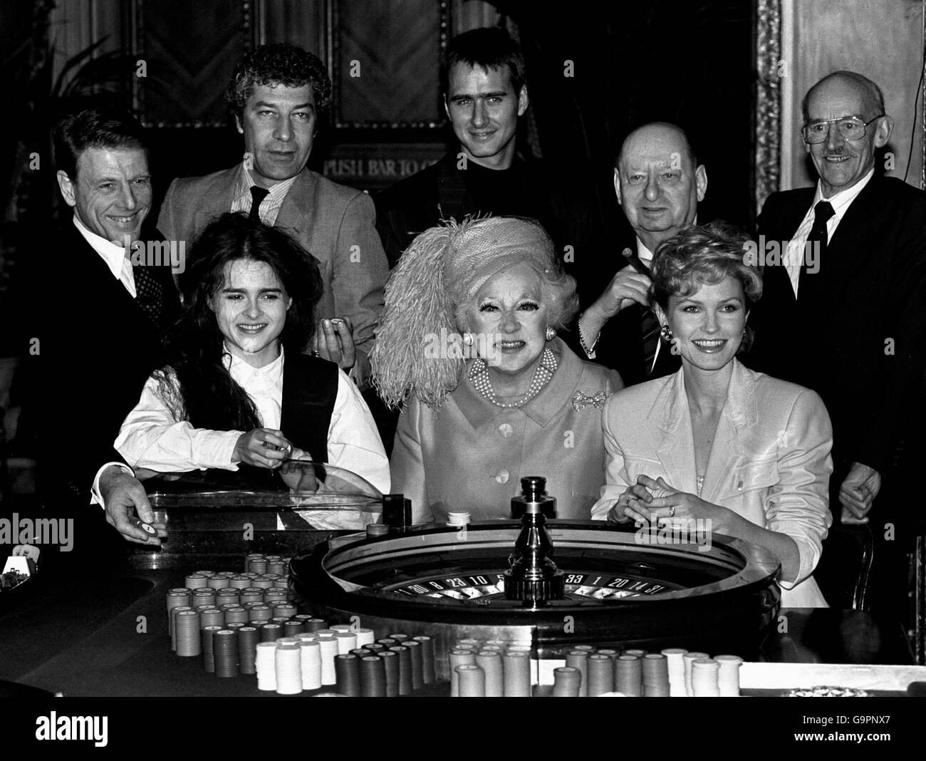 The stars of a new video taken from a Barbara Carland book, Hazard of Hearts, gather round a poker table. (back l-r) Edward Fox, Gareth Hunt, Marcus Gilbert, Lord Grade (Producer) and Albert Fennell (Producer). (bottom l-r) Helena Bonham-Carter, Barbara Cartland and Fiona Fullerton. Stock Photo