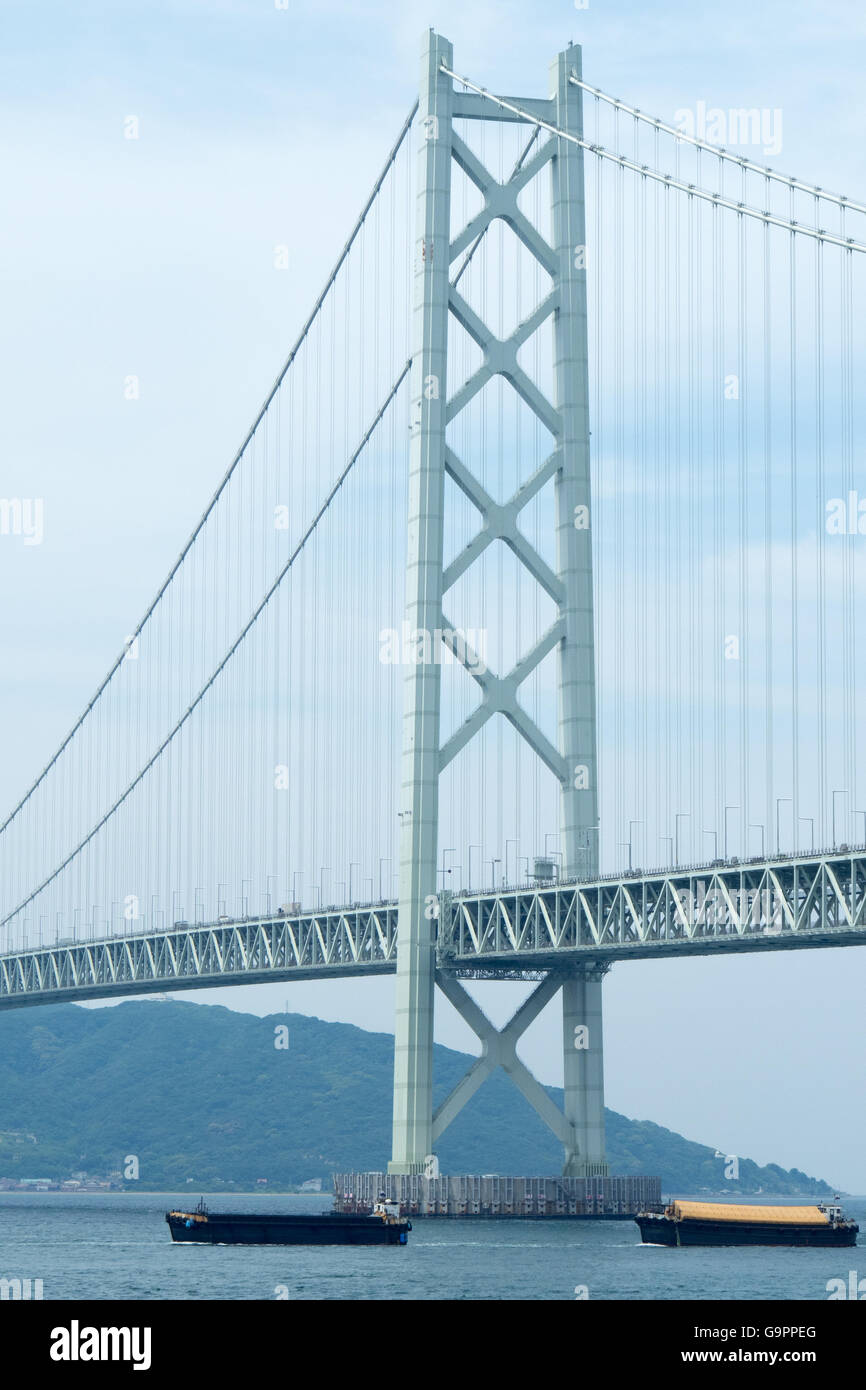 Ships passing under Akashi Kaikyo suspension bridge connecting Kobe to Awaji Island Stock Photo
