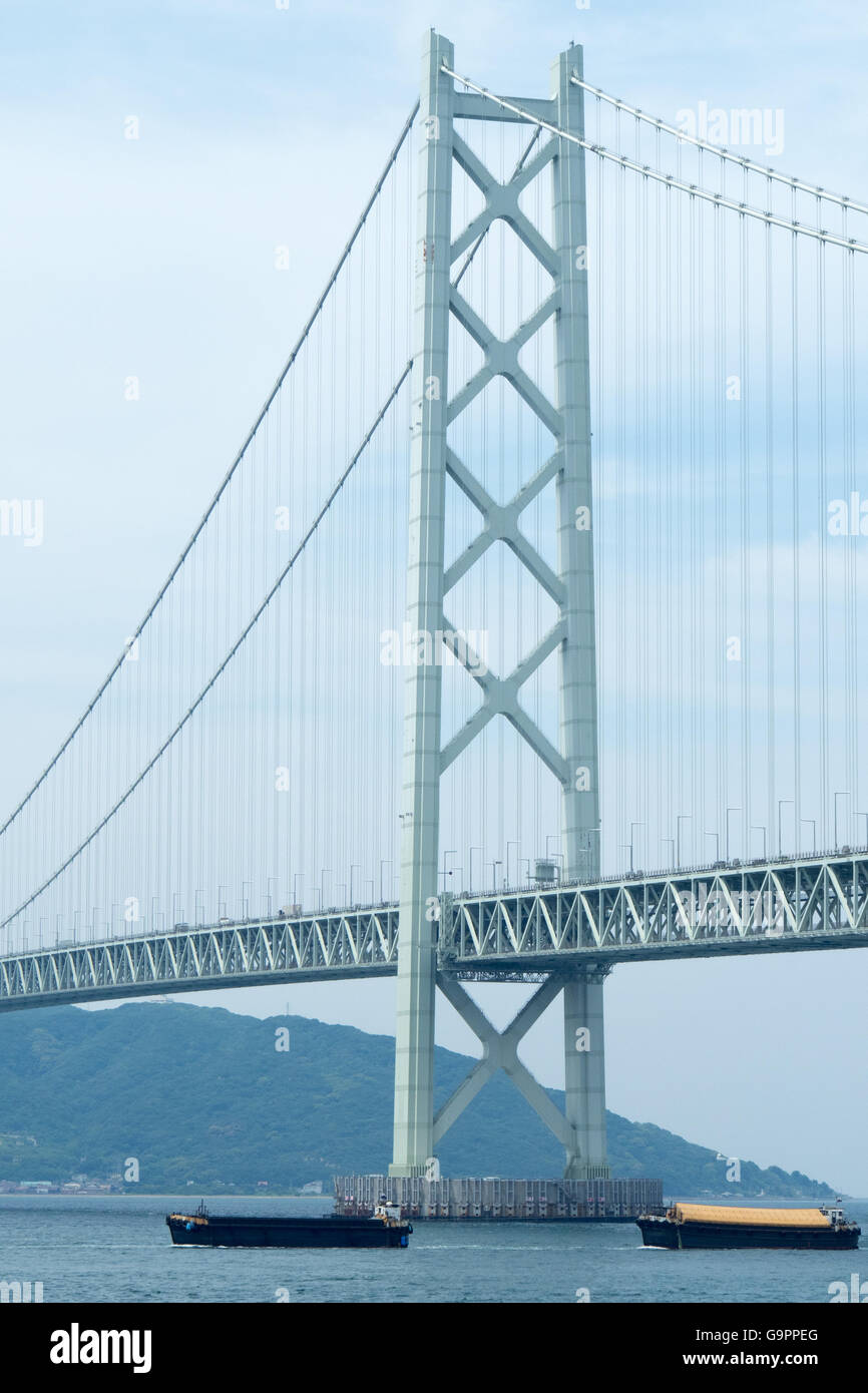 Ships passing under Akashi Kaikyo suspension bridge connecting Kobe to Awaji Island. Stock Photo