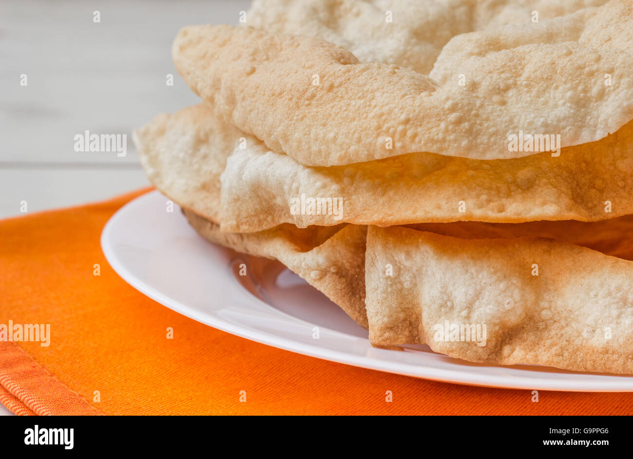 Fried pappadums on a white wooden table Stock Photo