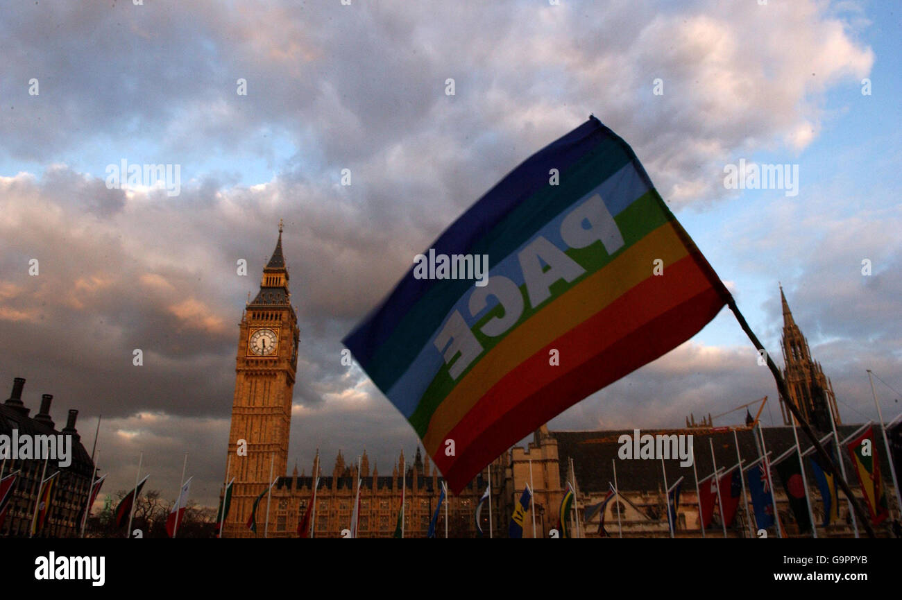 A demonstrator waves a peace flag at Parliament Square, London in protest against Britains trident weapons system vote which is taking place today. Stock Photo