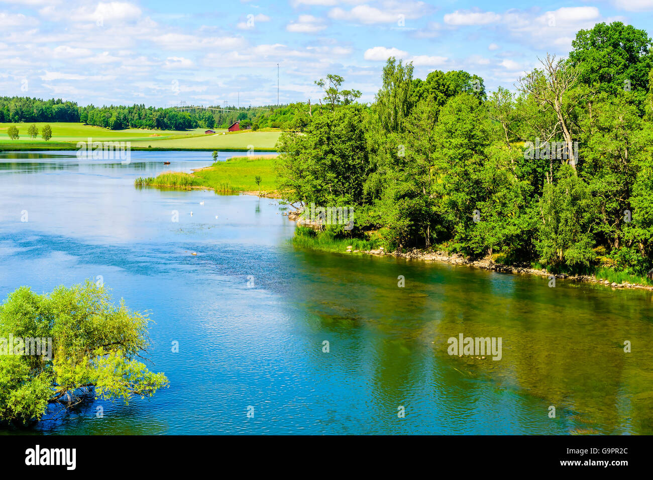 View over Norsholm nature reserve in Sweden. The river is Motala strom. In the distance there is a house. Summer in the Swedish Stock Photo