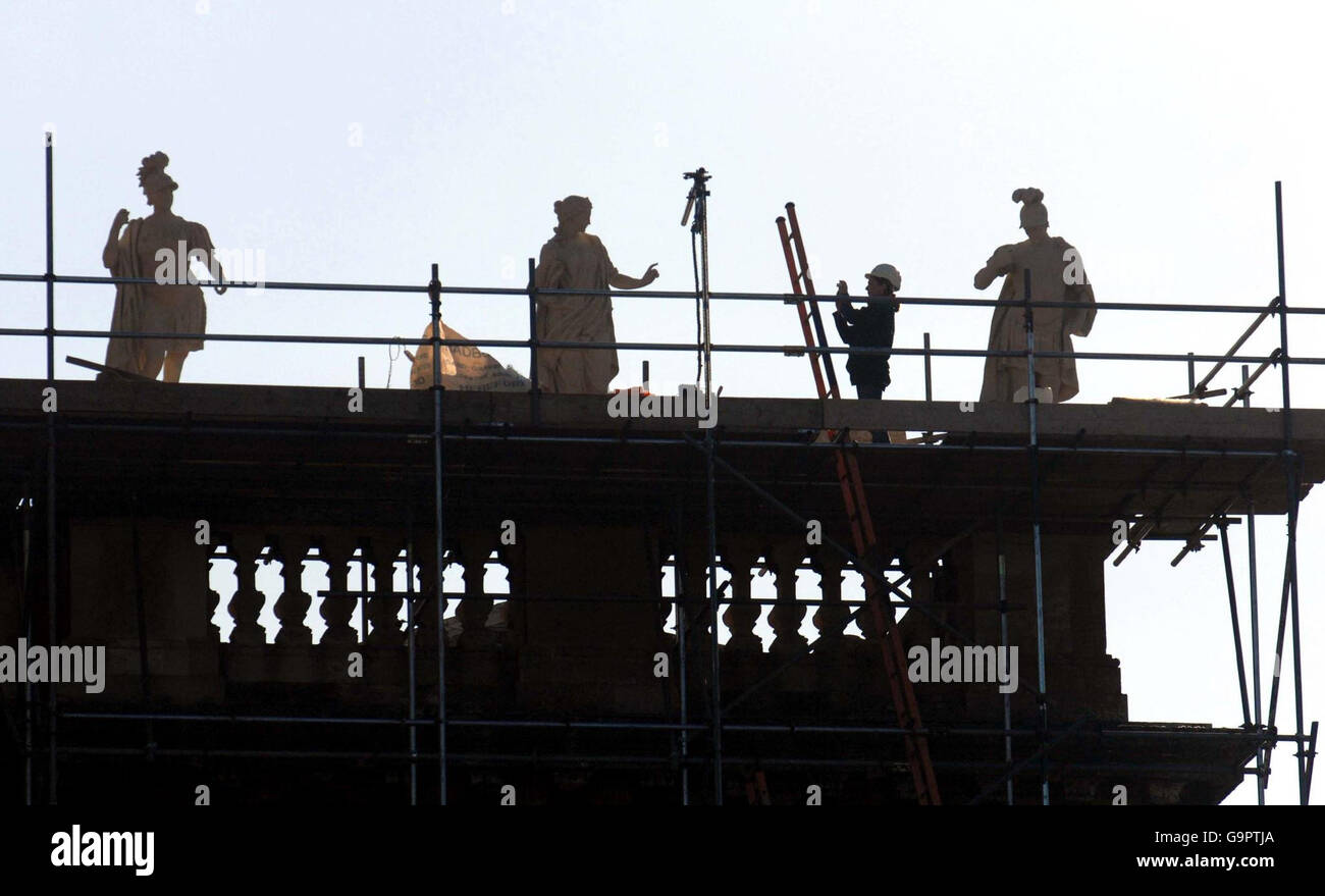 A worker photographs replacement statues on Blenheim Palace's North Facade. Stock Photo