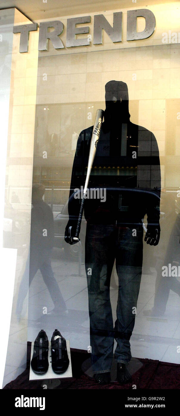 Trend shop in Liverpool city centre with a mannequin wearing a hoodie and armed with a baseball bat in the window display. Stock Photo
