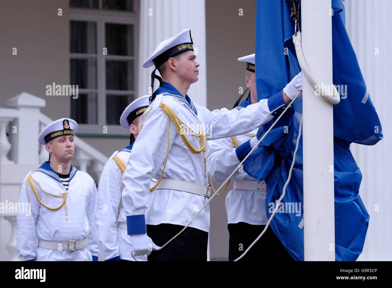 Lithuanian Armed Forces Honor Guard sailors raise the flag of the North Atlantic Treaty Organization (NATO) during Changing of Guards ceremony in front of  the Presidential palace in the old city of Vilnius, the capital of Lithuania Stock Photo
