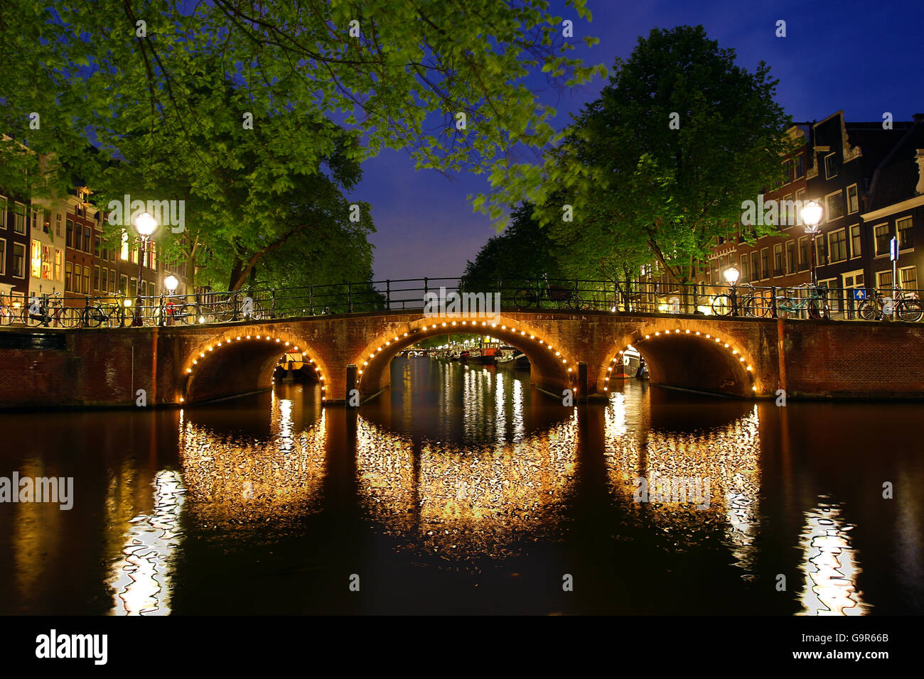 Illuminated Canal Bridge At Night On The Canal Between Prinsengracht And Brouwersgracht In