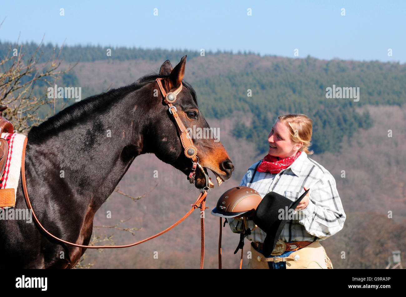 Woman with American Quarter Horse, stallion, western riding, crash helmet and hat / riding helmet, FEI Stock Photo