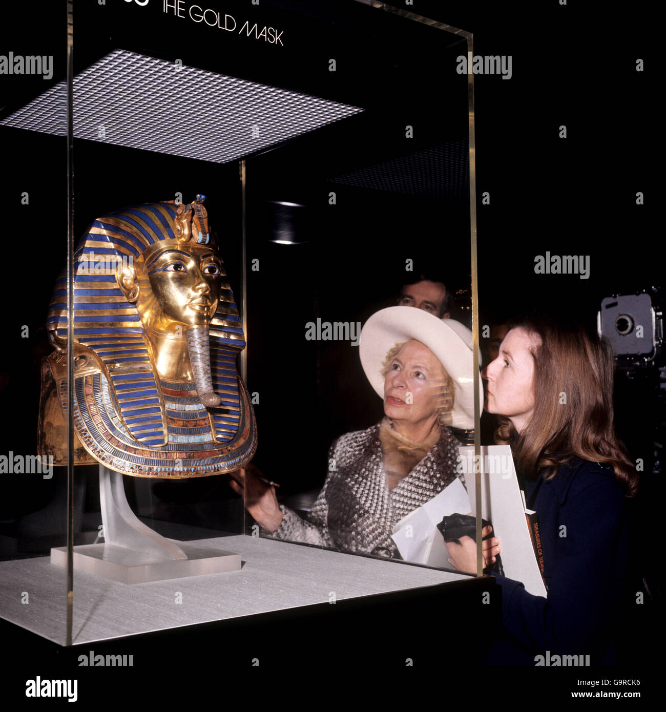 Visitors admire the solid gold face mask of Tutankhamun at the British Museum Exhibtion. Stock Photo