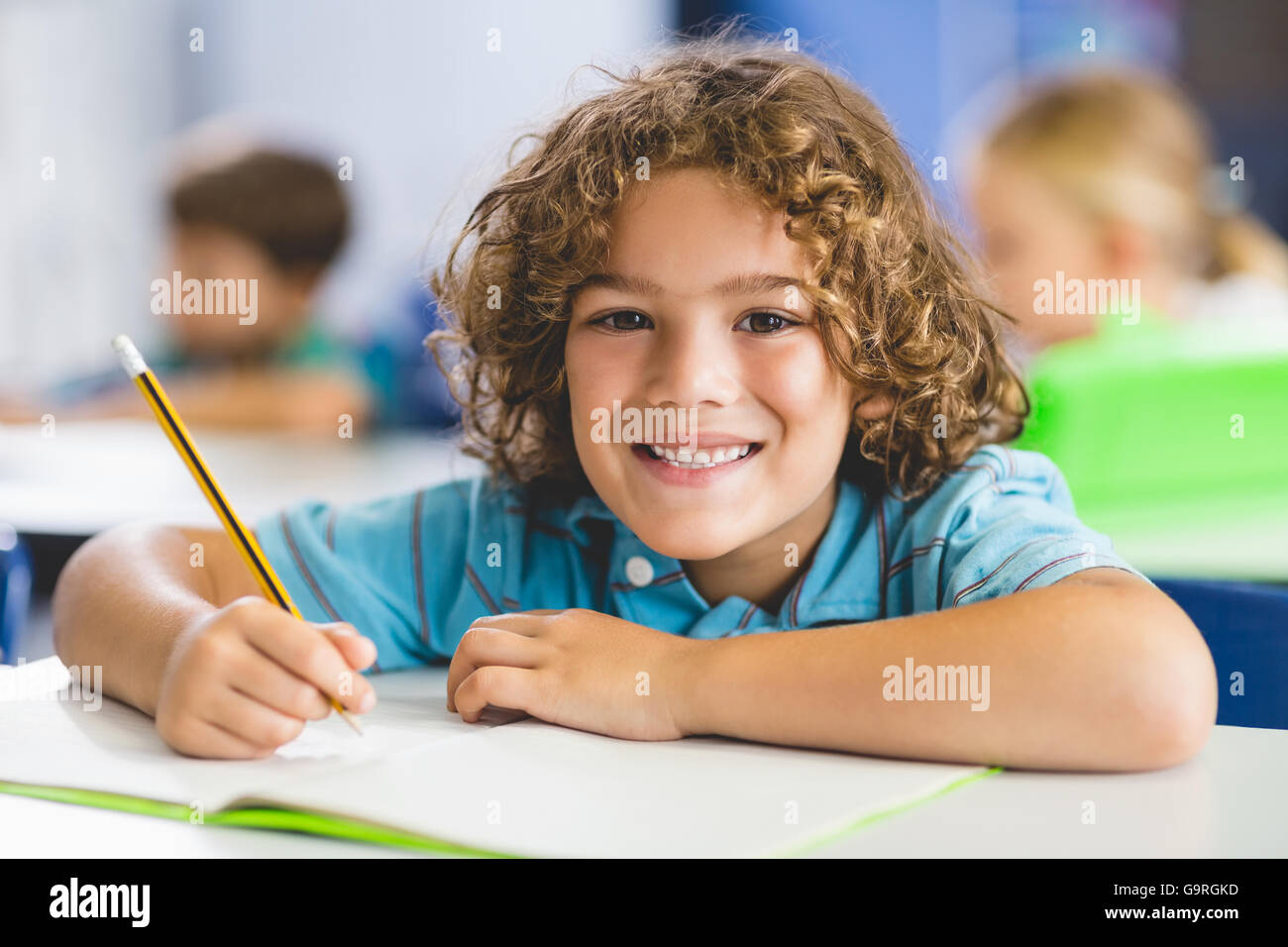 Portrait of schoolboy studying in classroom Stock Photo - Alamy