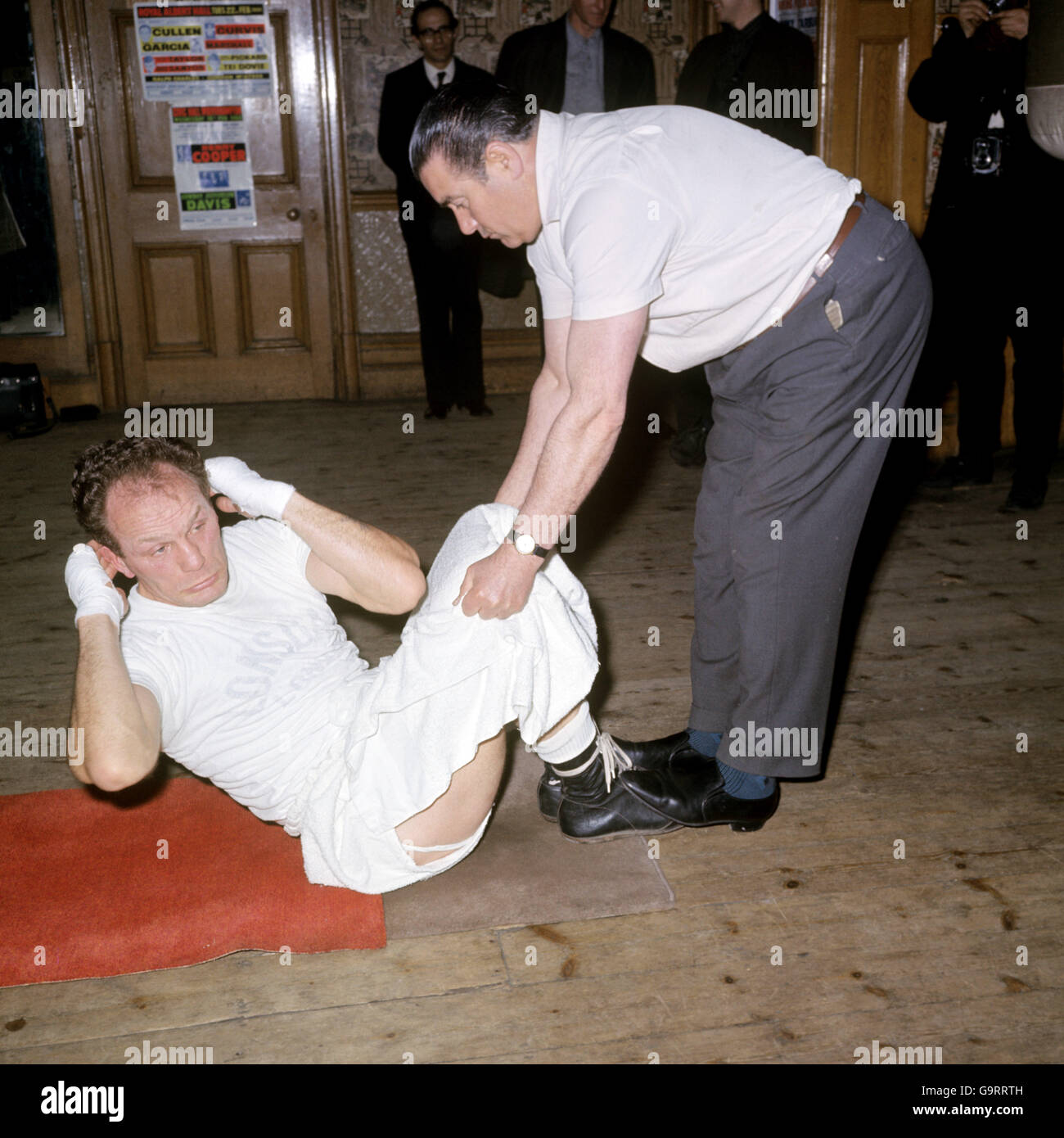 British heavyweight Henry Cooper is helped by trainer at Thomas A Becket gymnasium, Old Kent Road, London Stock Photo