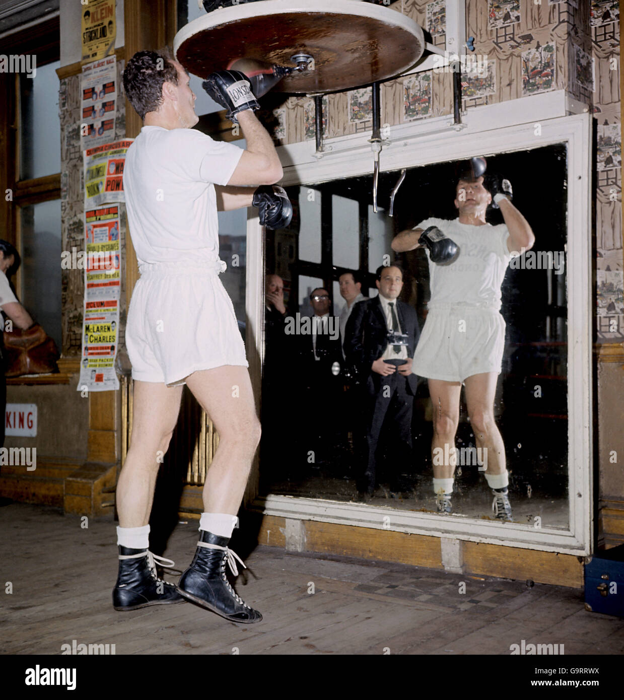 British heavyweight Henry Cooper has a work out on the punchball in the front of the mirror during trainig at Thomas A Becket Gymnasium, Old Kent Road, London Stock Photo