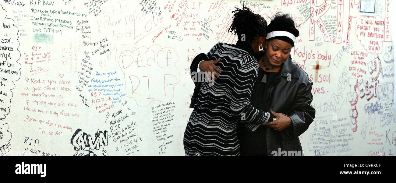 Family members of murdered schoolboy Kodjo Yenga cry in front of a wall of written tributes during a visit to the scene of his murder on Hammersmith Grove in London. Stock Photo