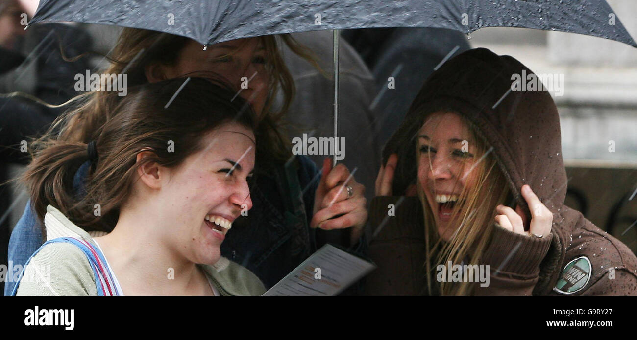 Girls shelter from a brief snow shower in central London. Stock Photo