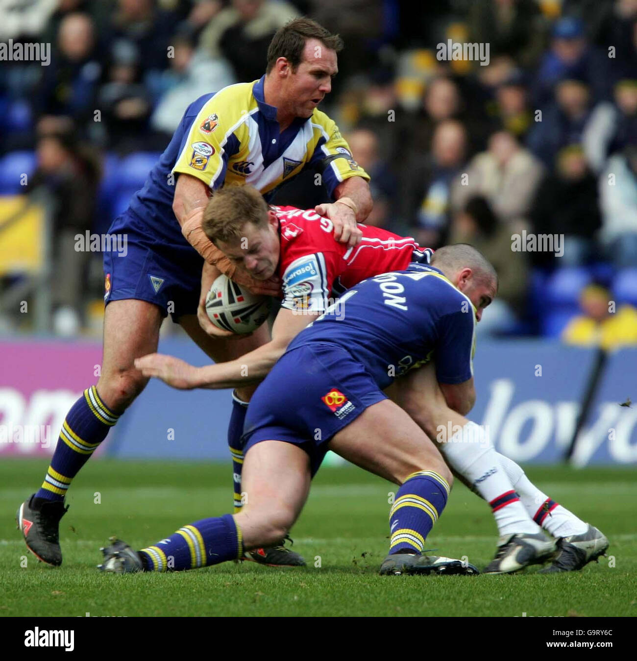 Hull KR's Jon Goddard (centre) is tackled by Warrington's Paul Johnson (right) during the engage Super League match at The Halliwell Jones Stadium, Warrington. Stock Photo