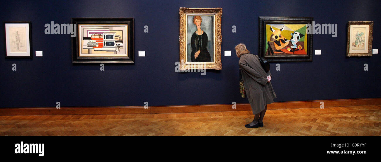 PICTURE. A woman looks at Amedeo Modigliani's Madame Menier, 1918, at Christie's in London before the Christie's Post-War and Contemporary Art sale taking place in New York on May 16. Stock Photo