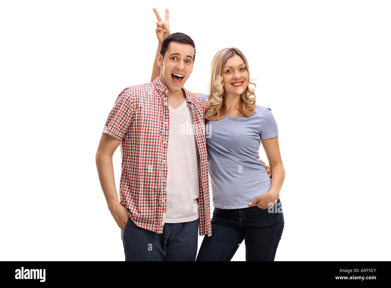Woman pranking her male friend with bunny ears isolated on white background Stock Photo