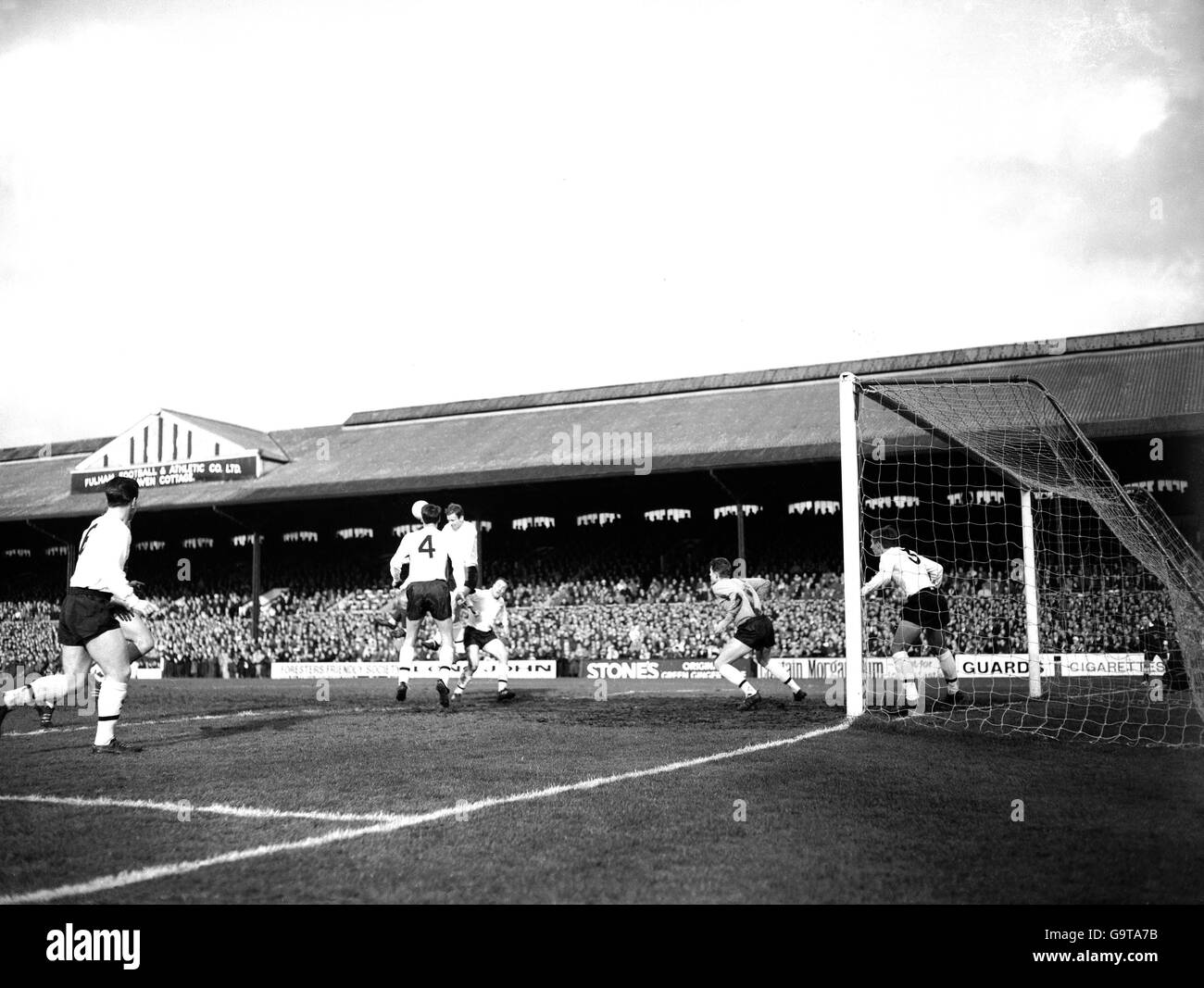 Fulham's John McClelland (second r), George Cohen (third r) and Bobby Robson (second l) look on as teammate John Dempsey (third l) heads clear Stock Photo